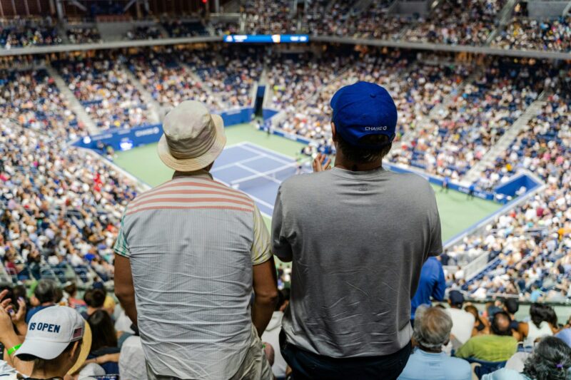Due spettatori seguono il match dall'Arthur Ashe Stadium di New York