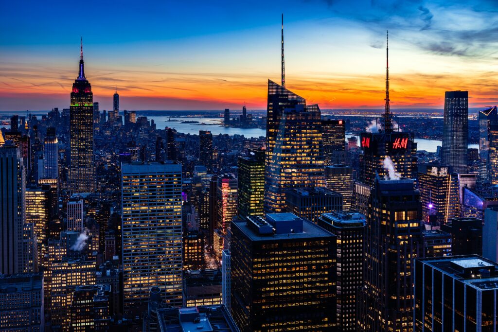 L'Empire State Building con la guglia illuminata nello skyline di New York al tramonto