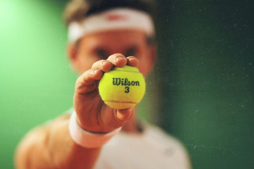 Un tennista mostra la pallina da tennis prima del servizio durante gli US Open