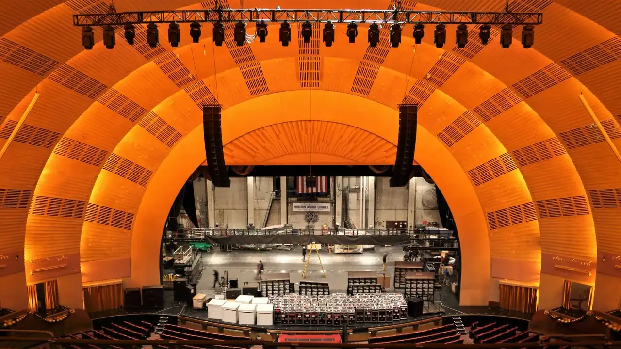 Gli archi dorati a sole nascente dell'auditorium del Radio City Music Hall visti dal mezzanino
